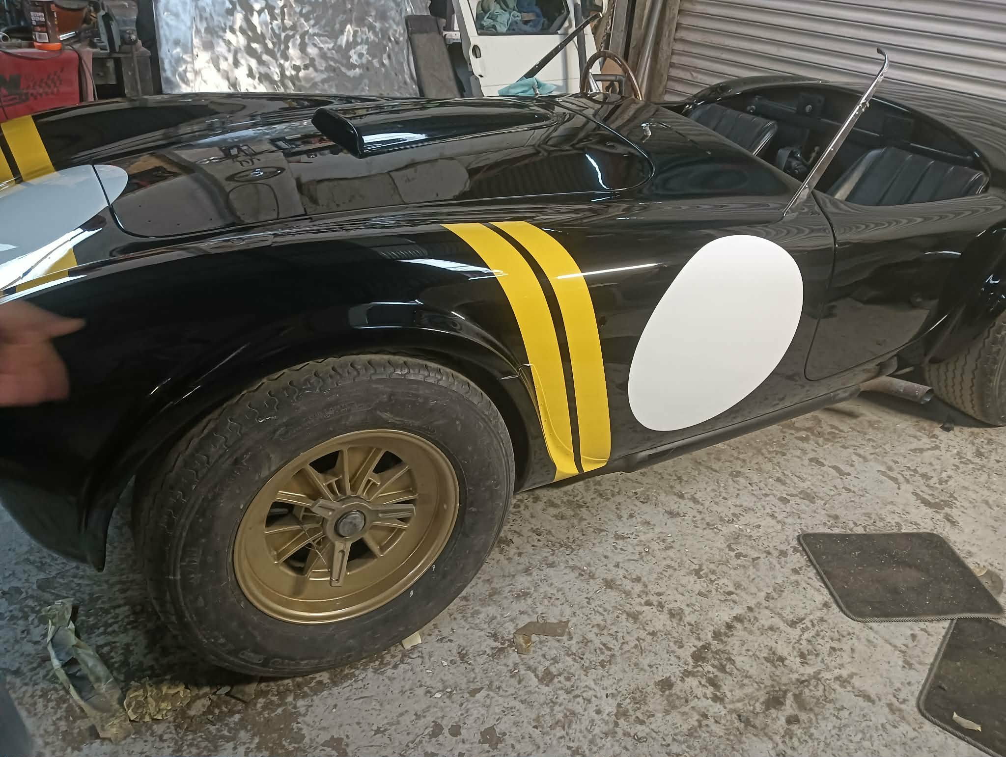 Classic Cobra gloss black bodywork with yellow stripes after full paint and masking control