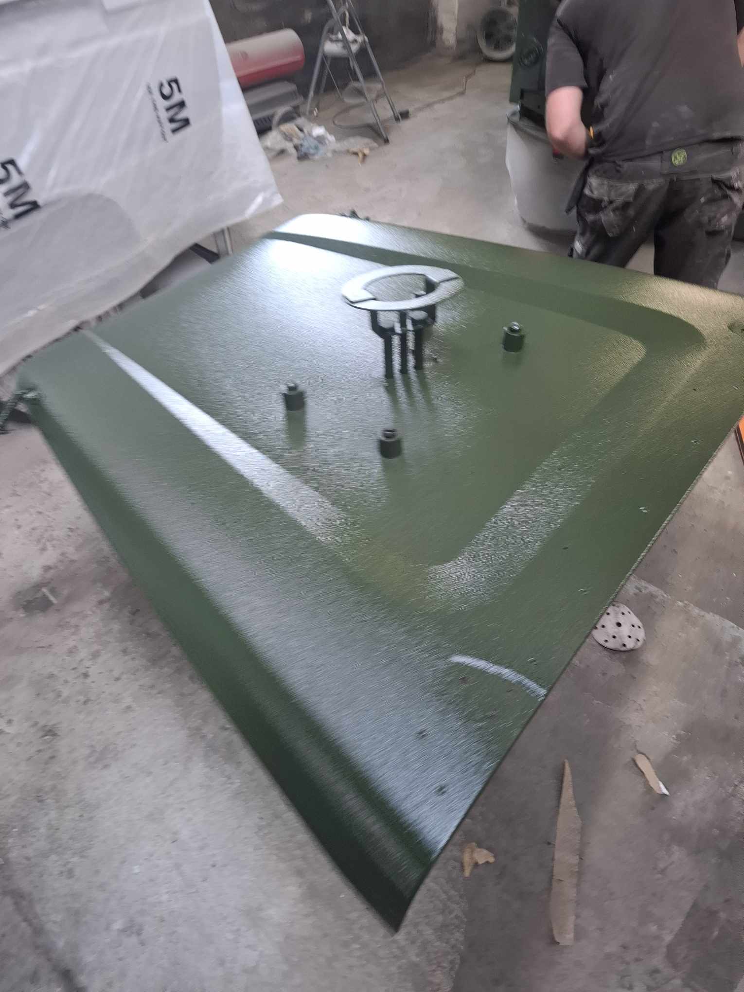 Textured green Raptor coating on Land Rover bonnet with controlled edge masking